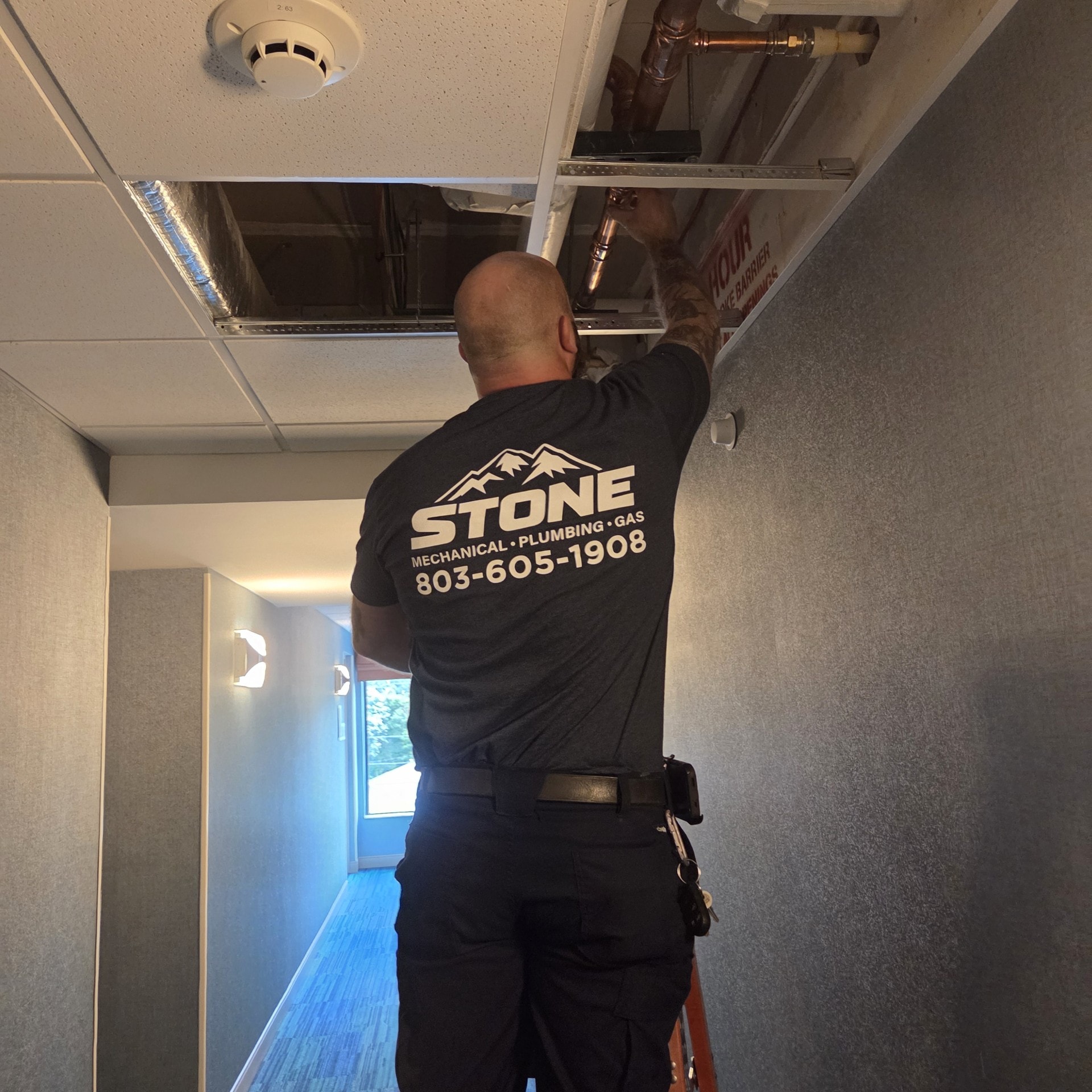 Stone Mechanical technician servicing Intellihot water heater unit